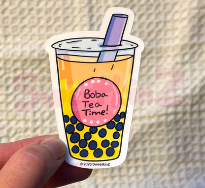Sticker of a bubble tea cup with a straw, held against a textured background.