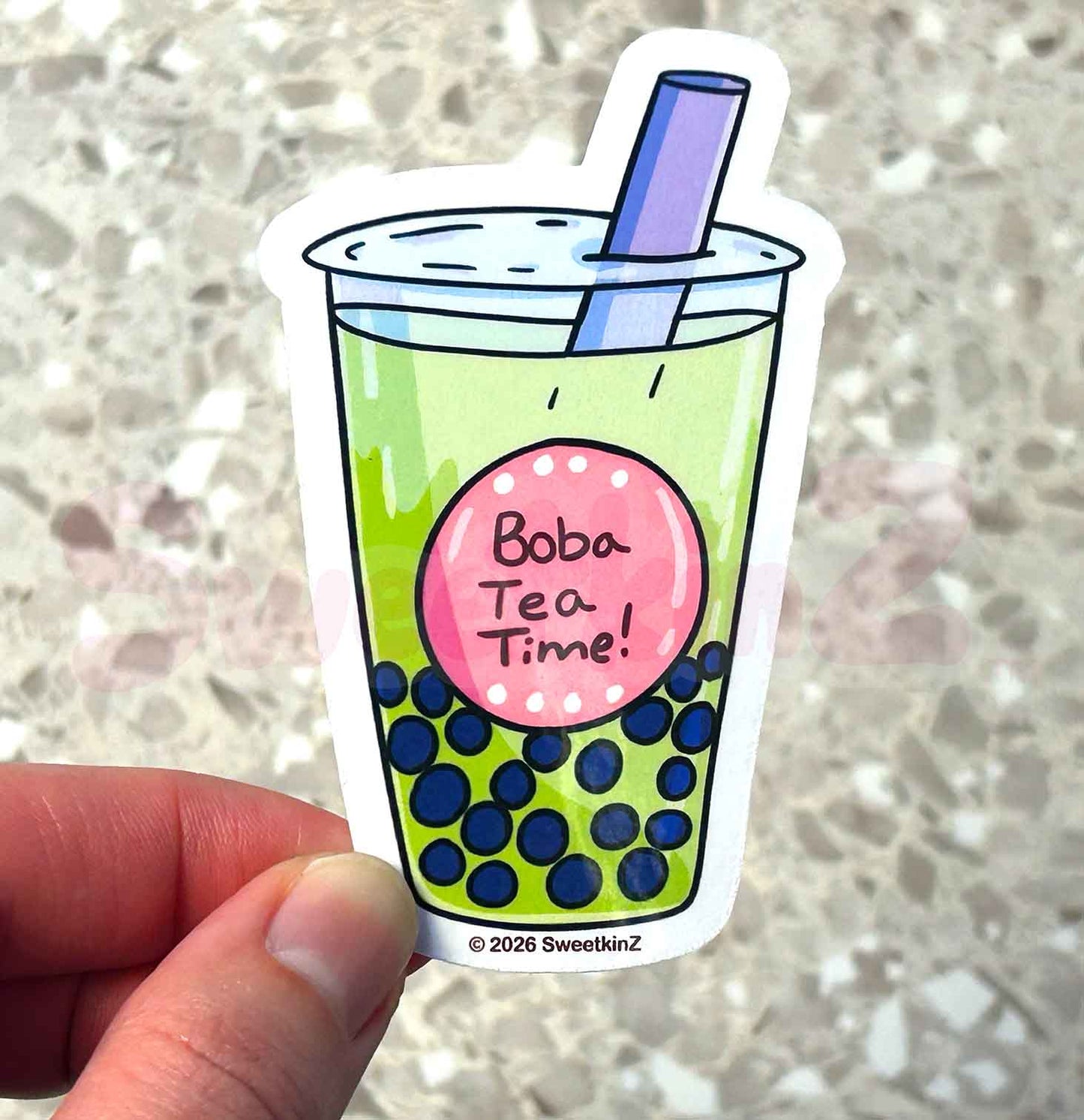 Sticker of a bubble tea cup with blue boba and a pink label saying 'Boba Tea Time!' held by a hand.