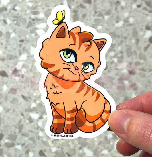 Cartoon cat sticker with a butterfly on a person's hand against a gray background