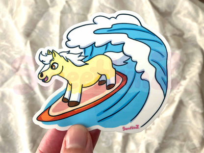 Sticker of a horse on a surfboard with a wave design, held against a neutral background.