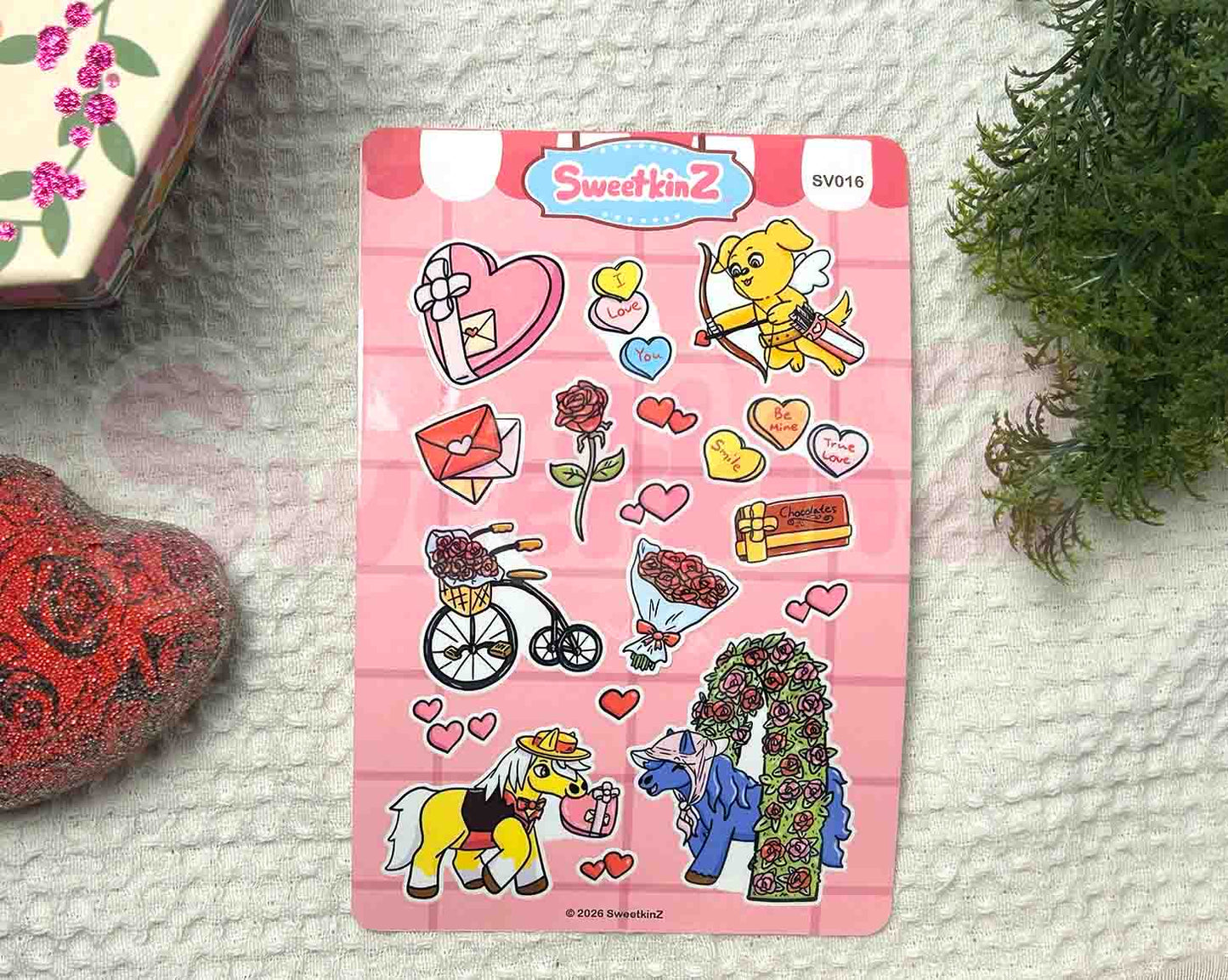 Valentine themed sticker sheet with cartoon animals, roses, and chocolates on a textured pink background